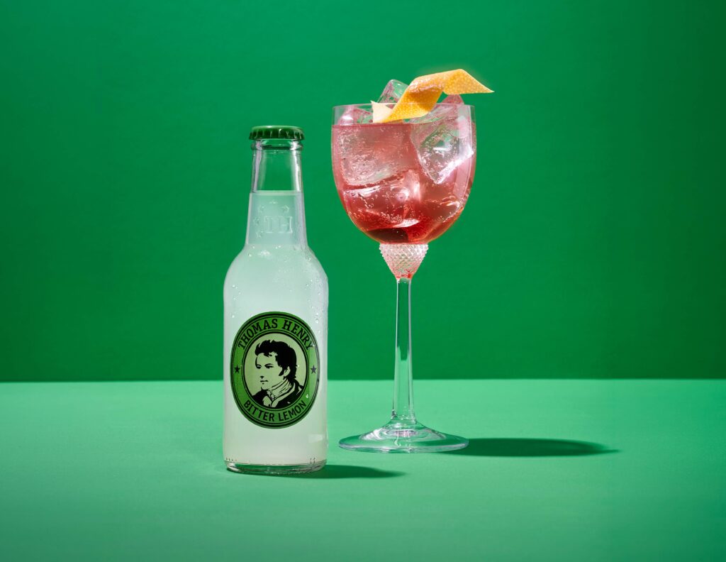 Thomas Henry Bitter Lemon mit 0,2l Glasflasche und Drink im Glas daneben