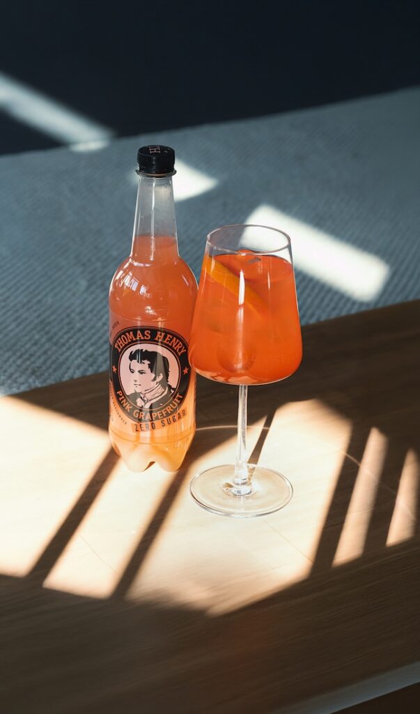 Aperol Grapefruit Spritz ZERO Drink im Weinglas. Rezeptbild mit Thomas Henry Pink Grapefruit ZERO