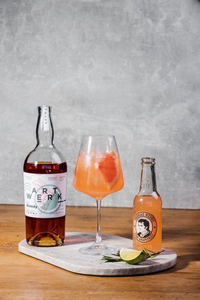 Artwerk Loma im Weinglas. Rezeptbild mit Thomas Henry Pink Grapefruit und Artwerk Brandy