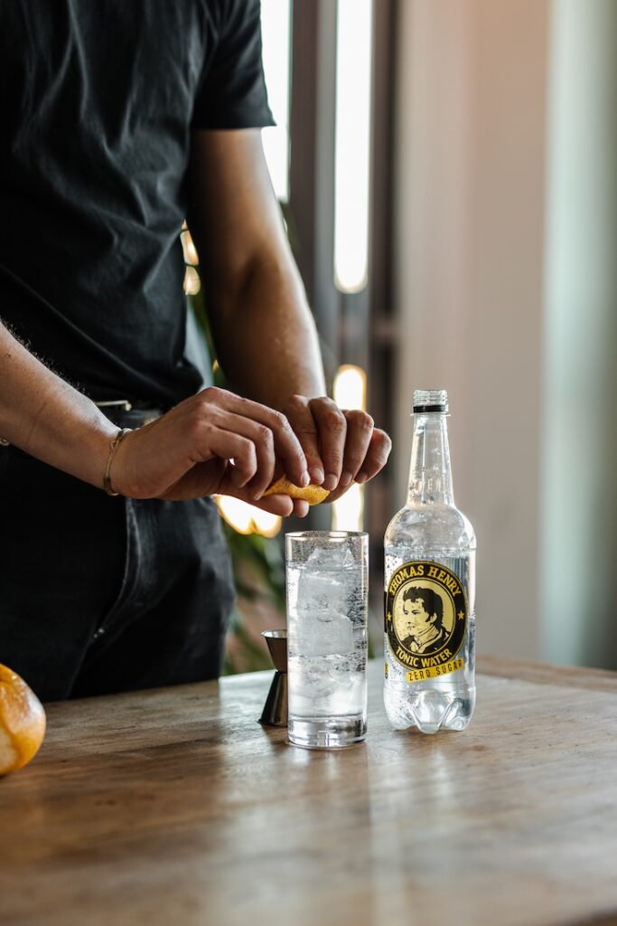 Gin & Tonic ZERO Sugar Drink im Highballglas. Drinkbild mit Thomas Henry Tonic Water ZERO und Orangenzeste