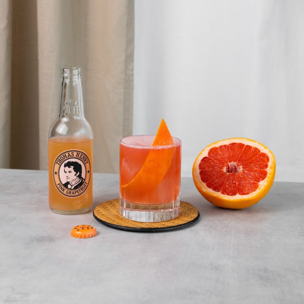 Monkey's Fruit Drinkbild im Tumbler mit Grapefruitzeste und Thomas Henry Pink Grapefruit