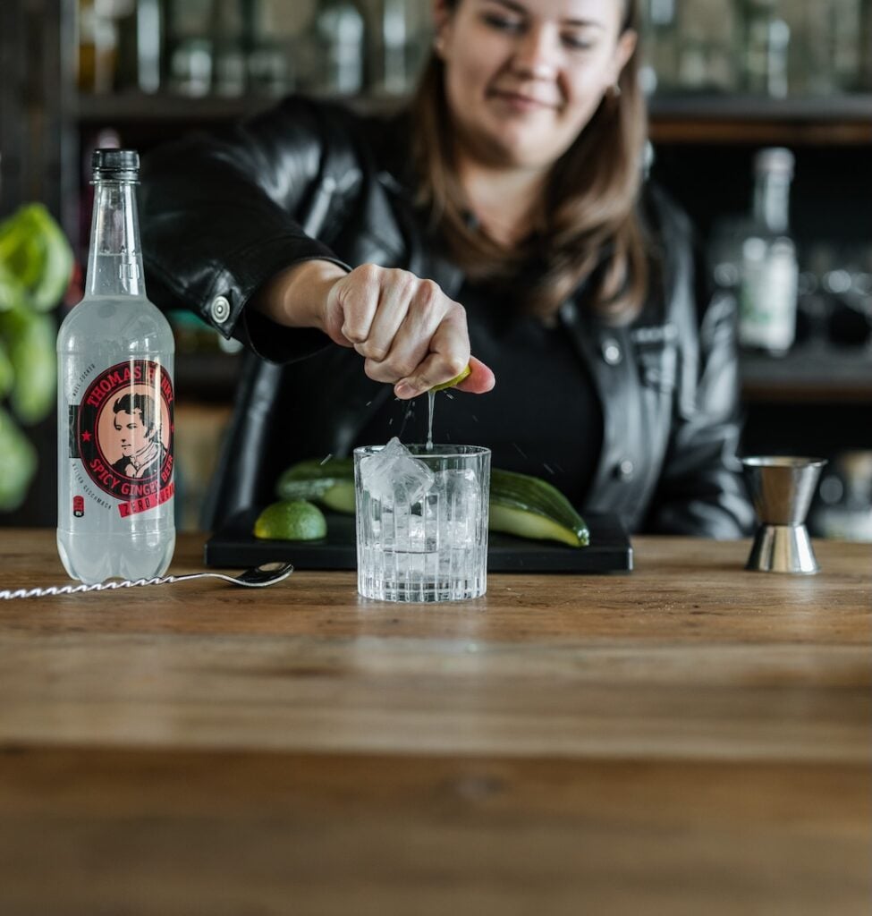 Bartenderin mixt Moscow Mule ZERO im Tumbler mit Thomas Henry Spicy Ginger ZERO