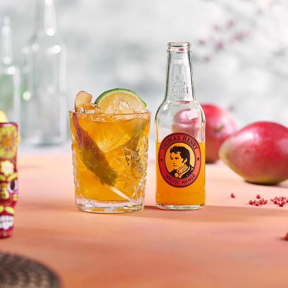 Mystic & Spice Drink im Tumbler mit Limettenachtel. Rezeptbild mit Thomas Henry Mystic Mango