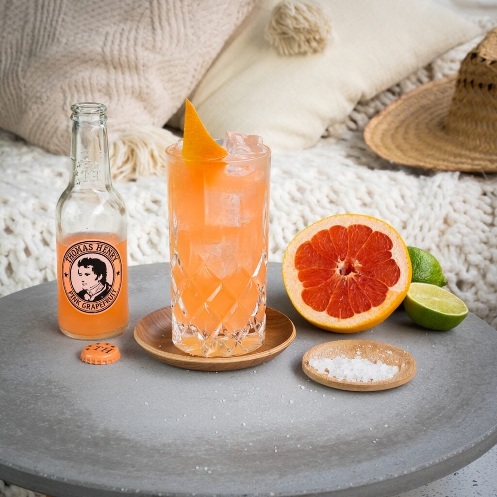 Palomito Drink im Highballglas mit Grapefruitzeste und Thomas Henry Pink Grapefruit